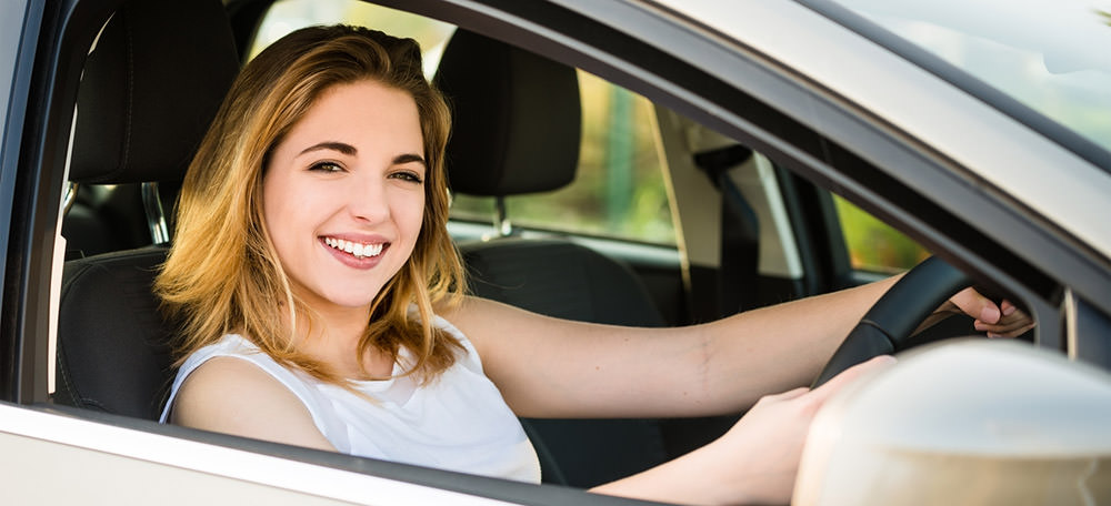 Smiling woman in her new white car