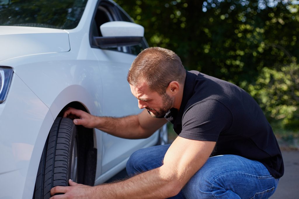 man doing basic car maintenance at home