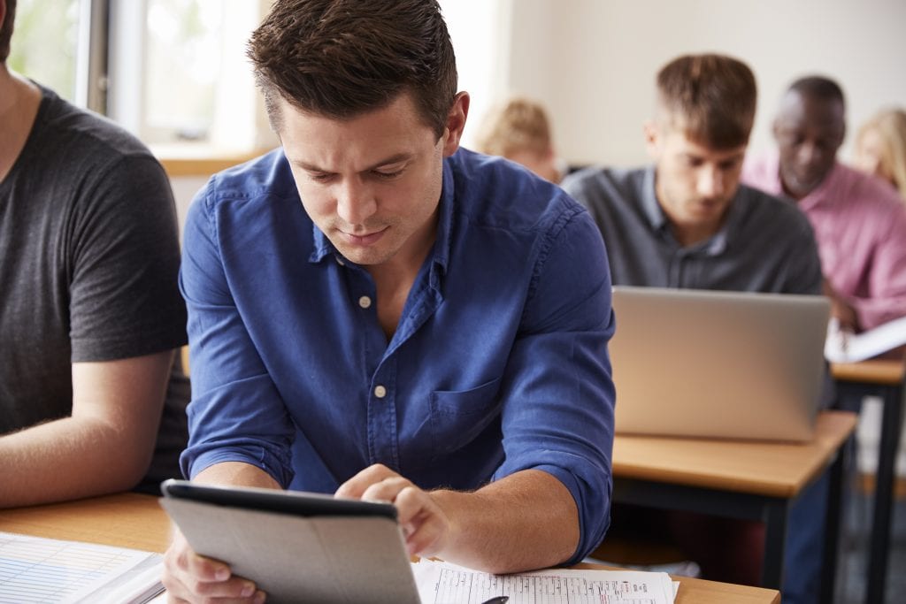 Mature Male Student With Digital Tablet In Adult Education Class classroom learning
