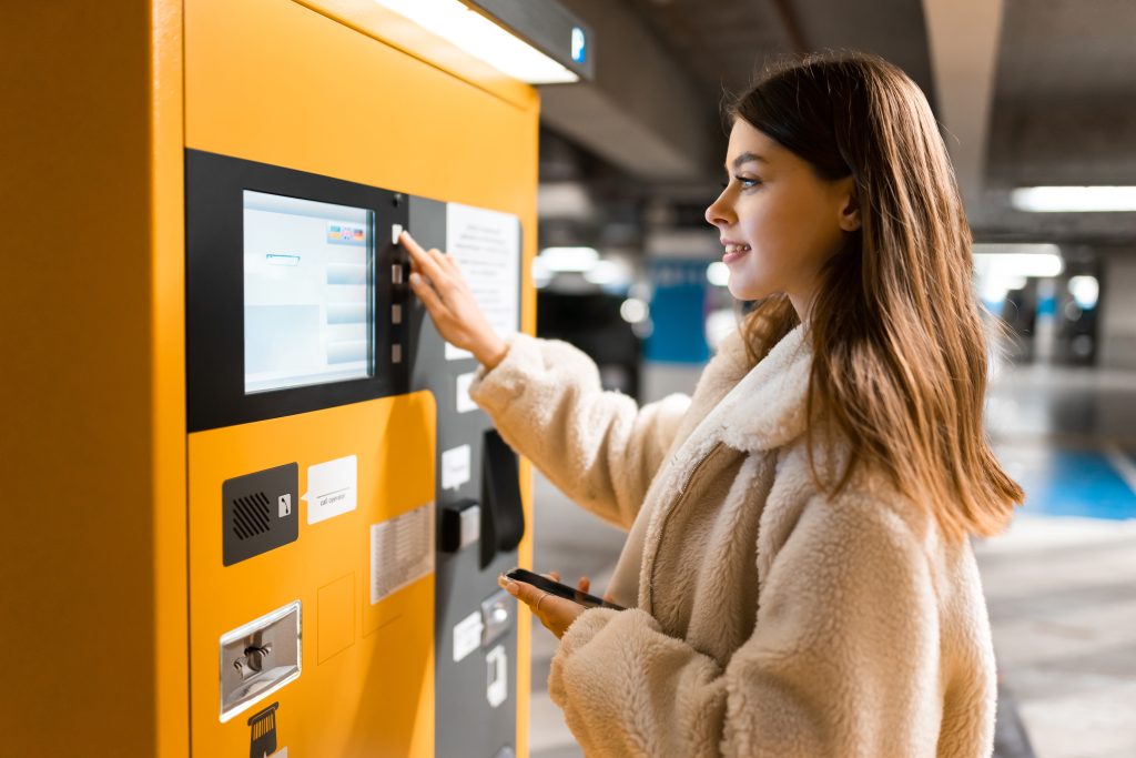 woman using uk parking payment machine