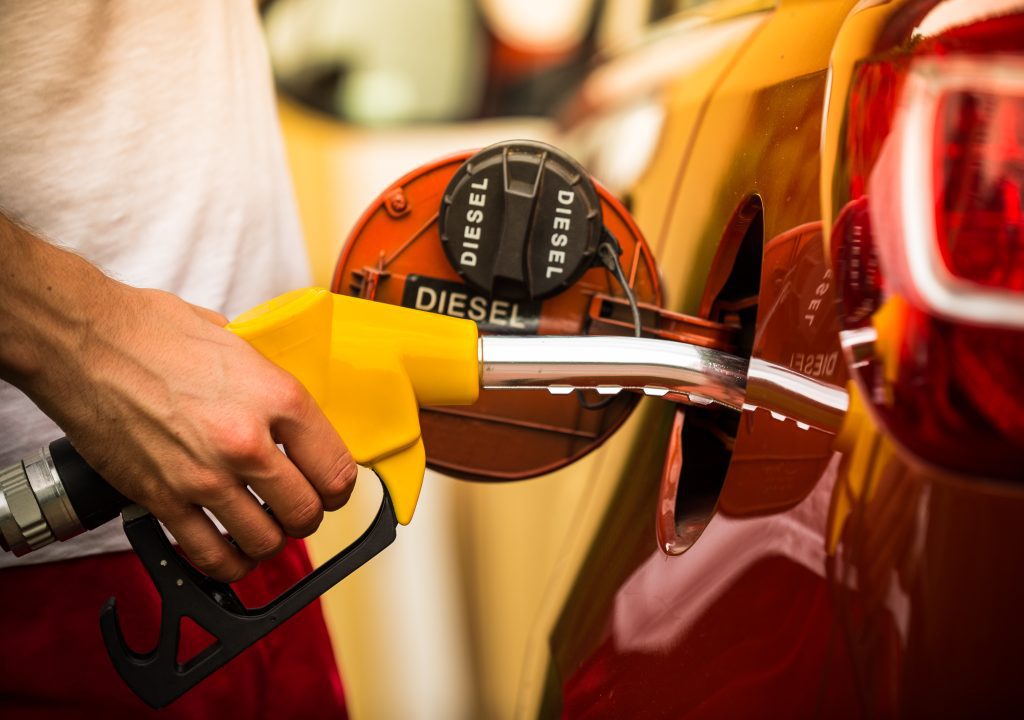 man filling car with diesel