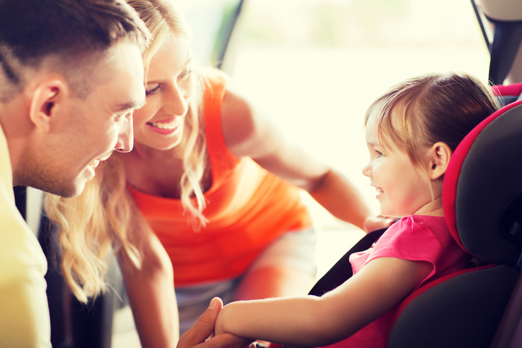 Happy couple putting child in car