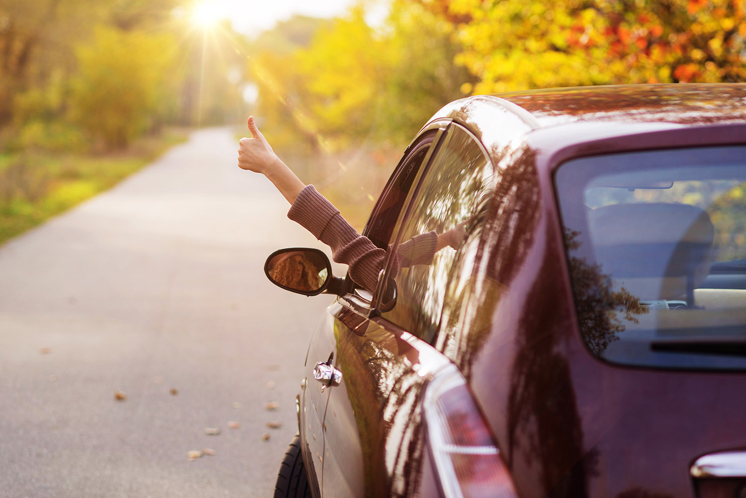 Girl in car giving thumbs up