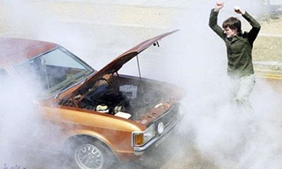 An angry man shouting at his broken down car