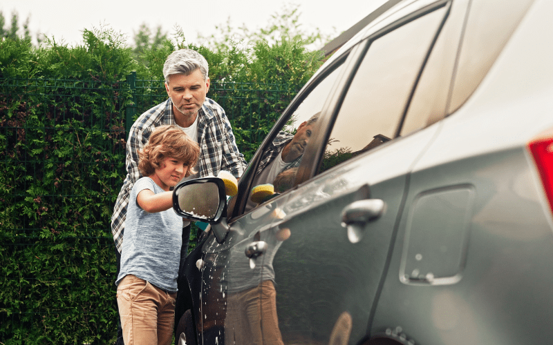 father and son washing car together