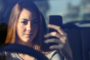 woman using mobile phone in car