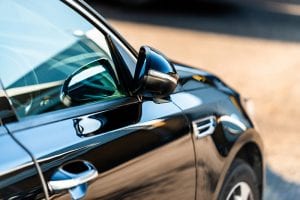 side door of a luxury car parked outside on a sunny day new car on car dealerships forecourt