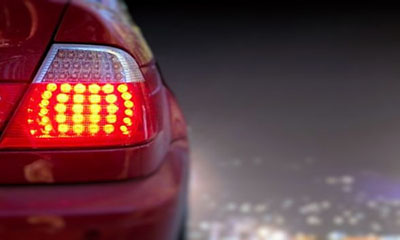 Close up of a red car with indicator light on